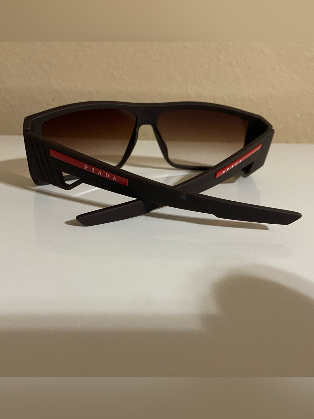 Prada Black Frame Sunglasses with Brown Gradient Lenses and Red Temple Accents
